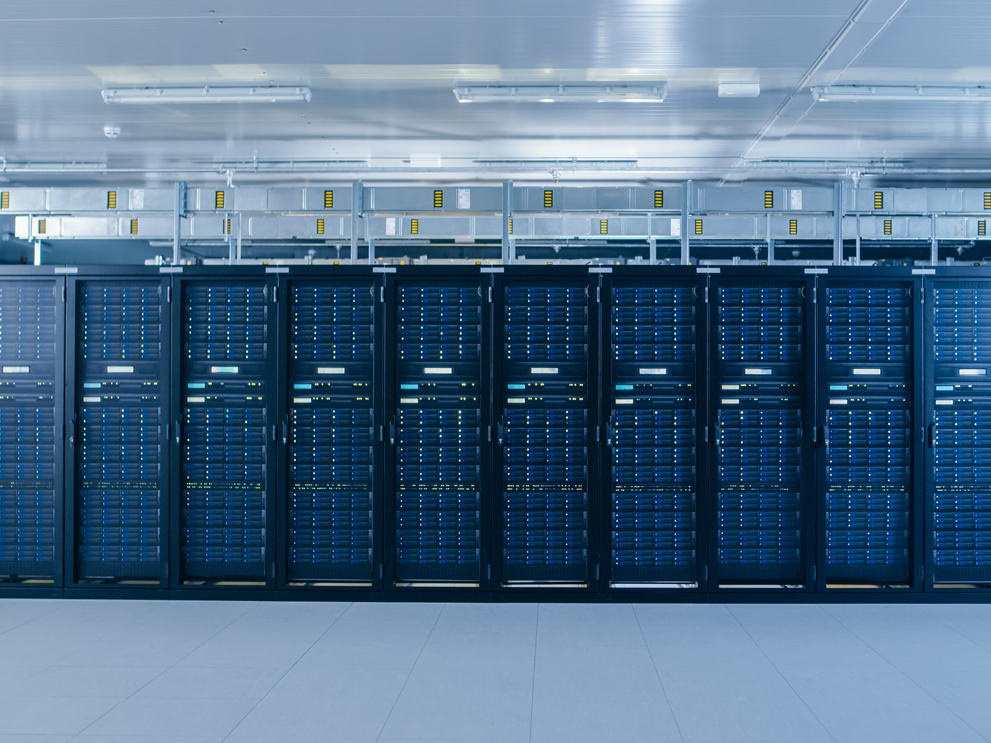 Data centre hall with rows of server racks monitored for temperature, leaks and access