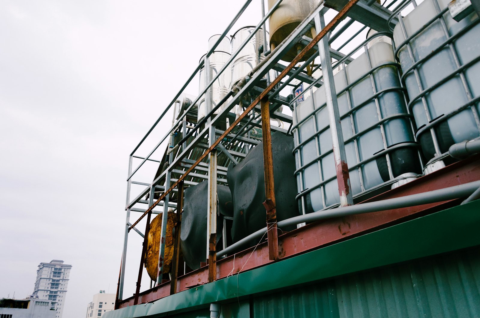 White IBC totes in metal cages stored on a building rooftop